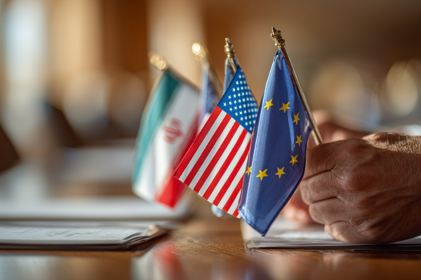 Diplomatieke vergaderruimte met vlaggen van Iran, VS en EU-landen, symbolisch voor internationale nucleaire onderhandelingen